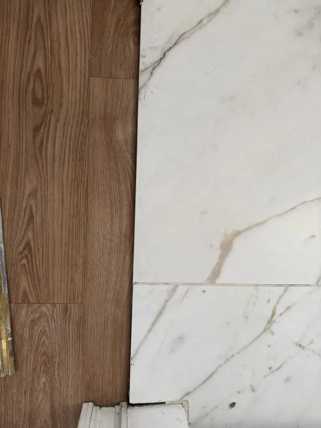 Avant : jonction entre le parquet de l'entrée et le carrelage de la salle de bain, sans barre de seuil.