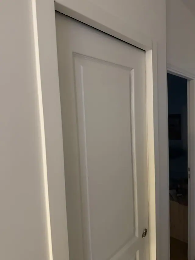 Avant : porte à galandage Scrigno affaissée, jour irrégulier entre le haut de la porte et le linteau.