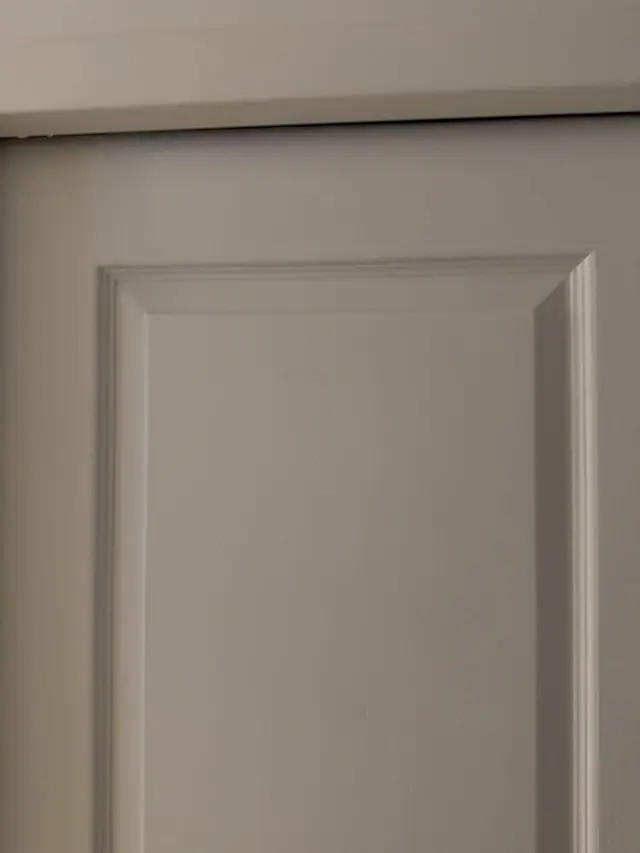 Avant : détail du jour irrégulier en haut de la porte, plus large d'un côté.